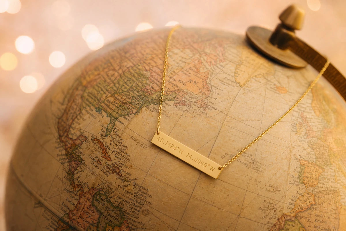 Gold coordinates necklace draped over vintage globe - 50 romantic places for coordinates jewelry