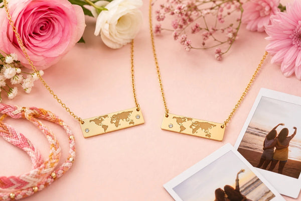 Sentimental best friend gifts featuring matching coordinates necklaces displayed with flowers and polaroid photos celebrating friendship