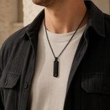 Man wearing a black initial bar necklace with letter A