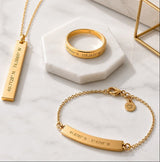 Gold jewelry including a necklace, ring, and bracelet on a marble surface with 'ourcoordinates.com' branding.